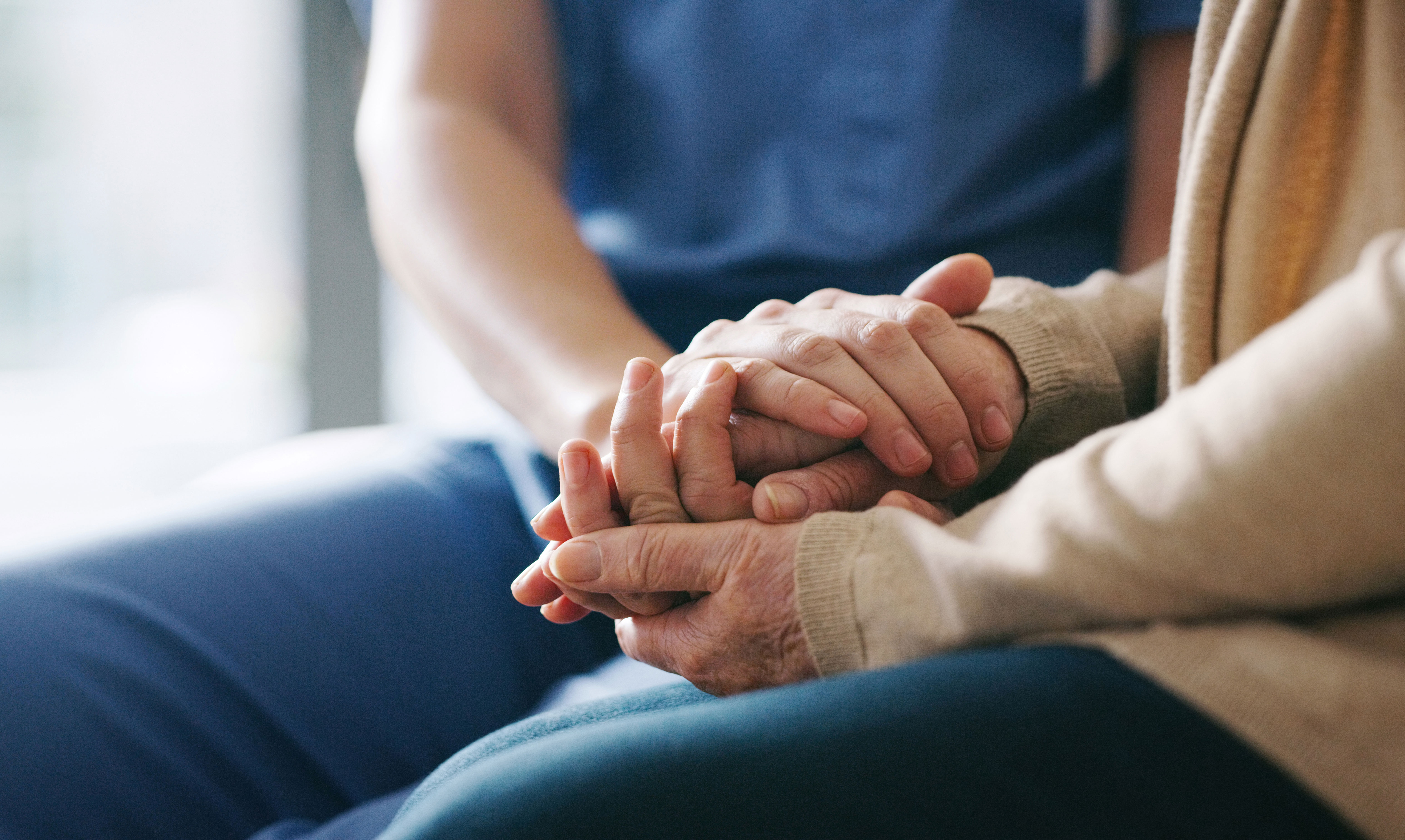 Two people holding hands comforting each other Two people holding hands comforting each other