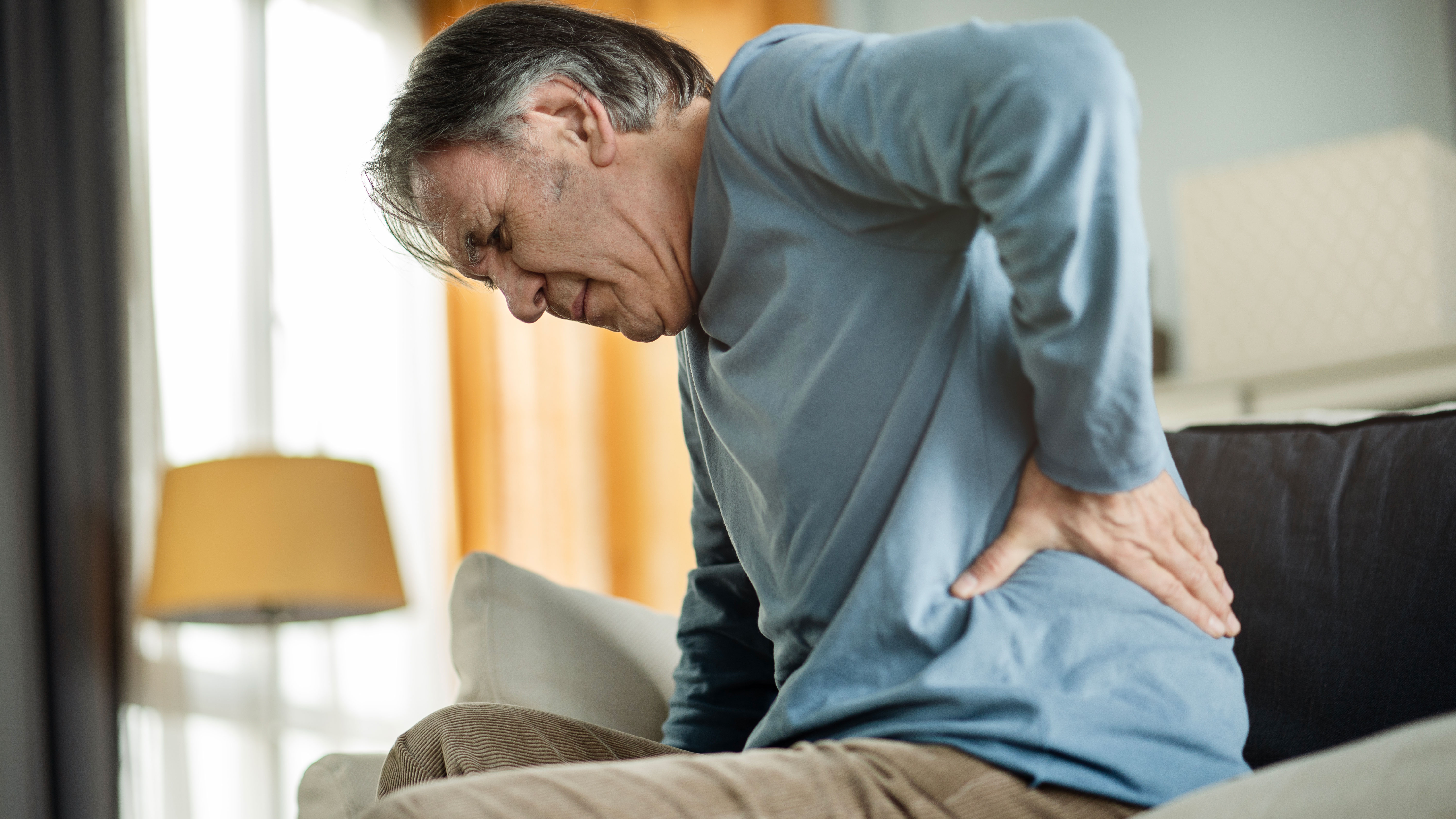 Older man holding back in pain