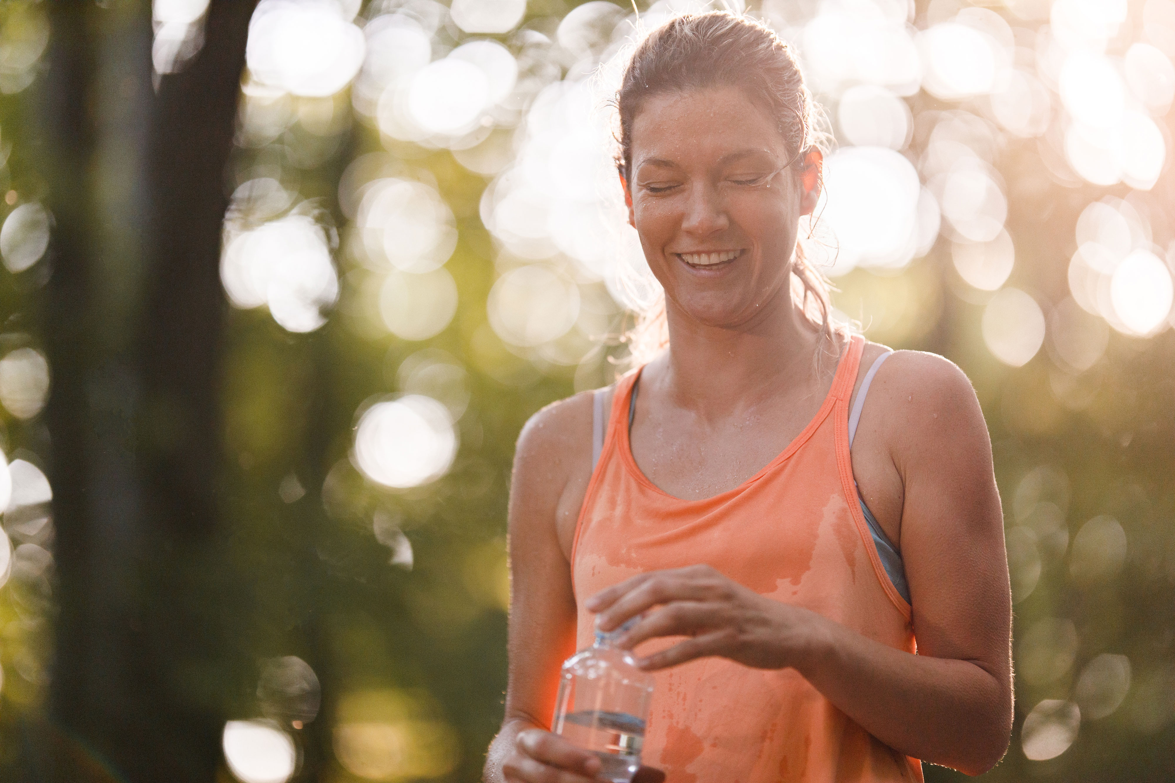 sweaty-female-runner-taking-cap-off-water-bottle