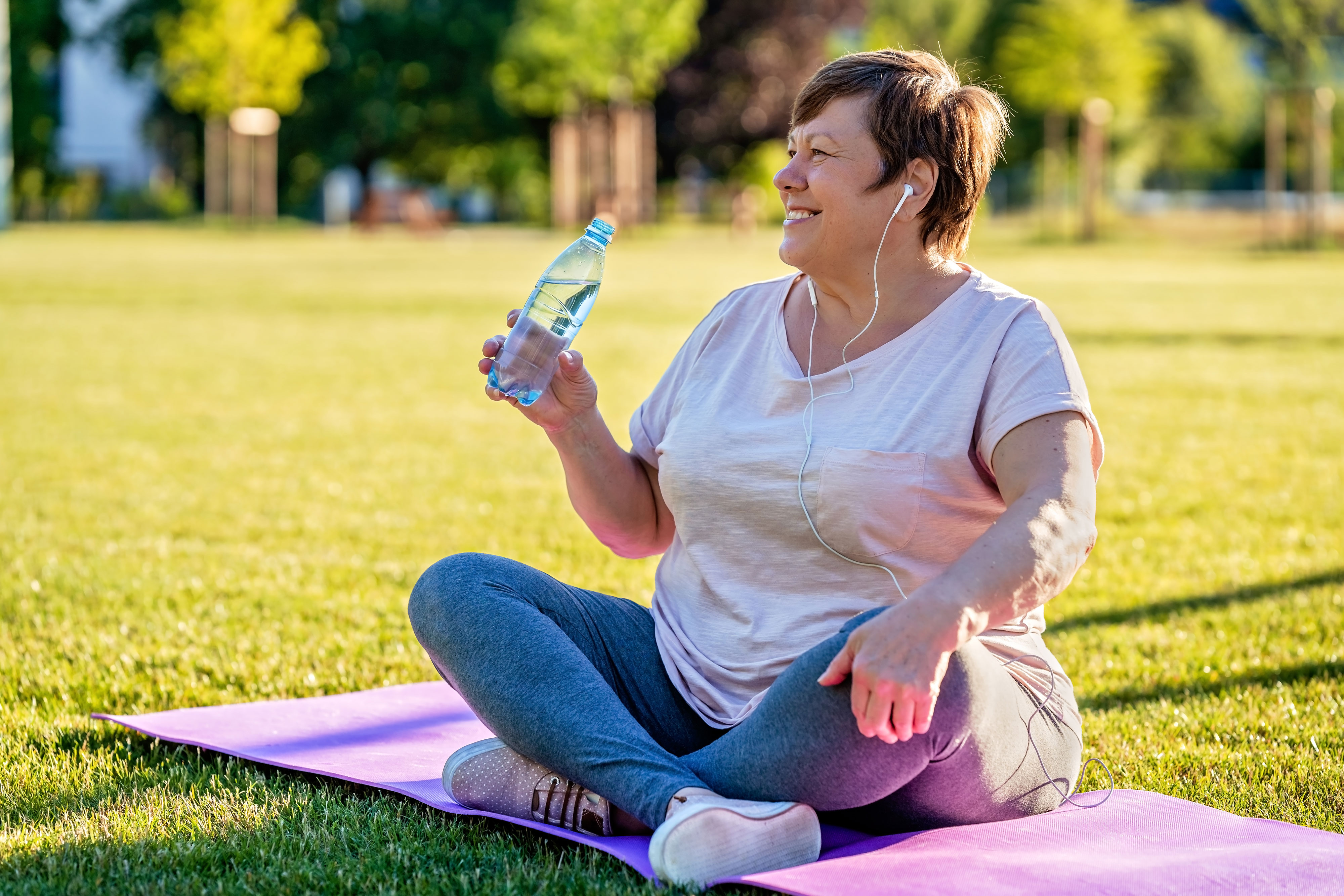 Woman on yoga mat outside