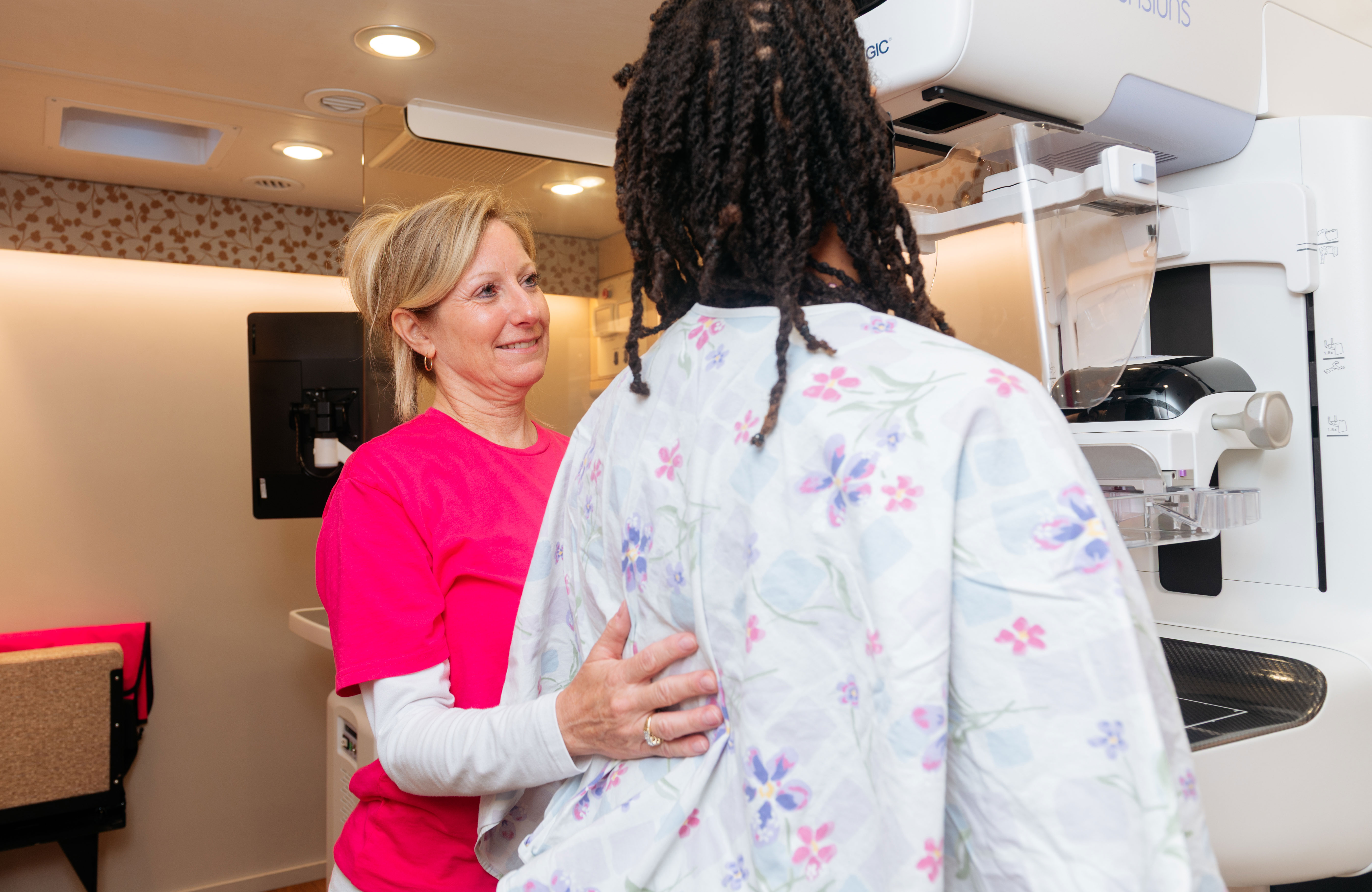 Technician helps woman get a mammogram
