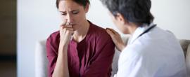 Sad patient being comforted by doctor