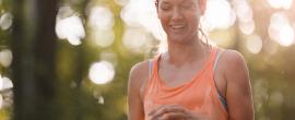 Sweaty female runner taking cap off water bottle