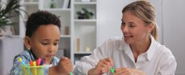 A child works with a teacher on writing