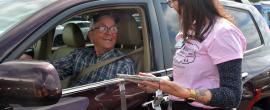 An employee talks to a man about to get a flu shot from his car