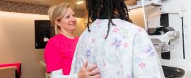 Technician helps woman get a mammogram