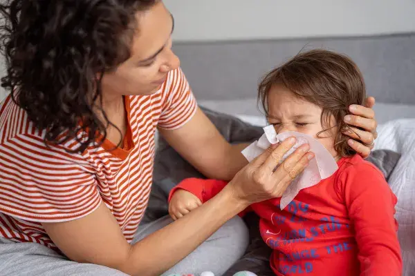 Mother helping child wipe nose