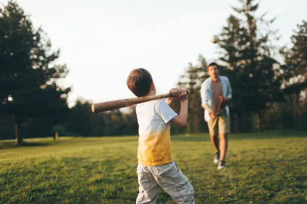 A father and son getting exercise playing backyard baseball