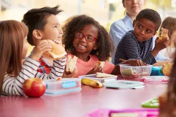 Young kids eating school lunch together