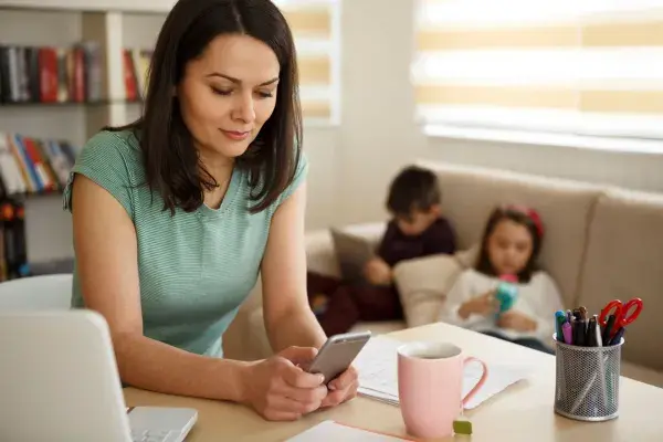Mom on phone with kids in background