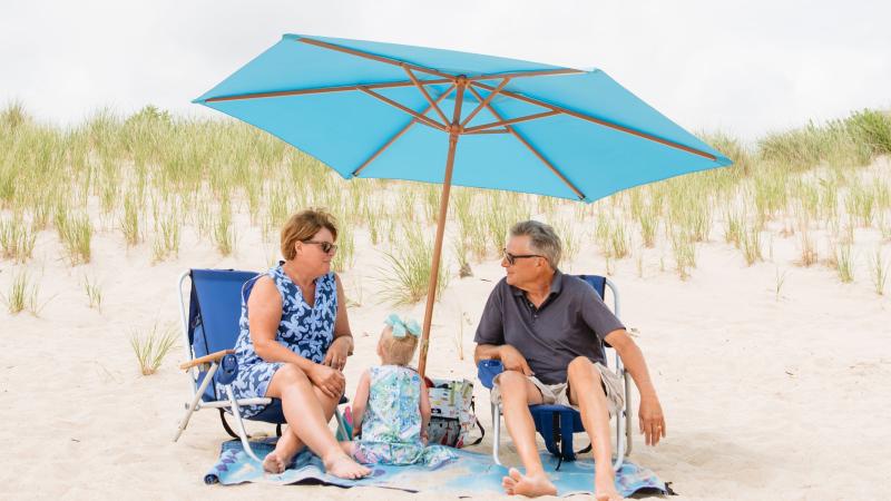Family sitting under a beach umbrella