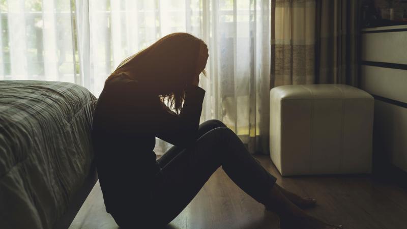 A depressed woman sitting in a dark room