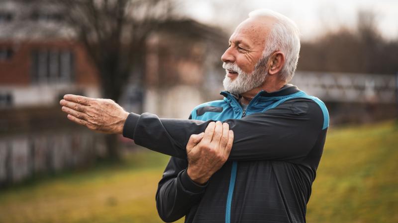 Senior man stretching his arm