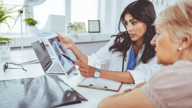 Doctor looking at lung x-ray with patient