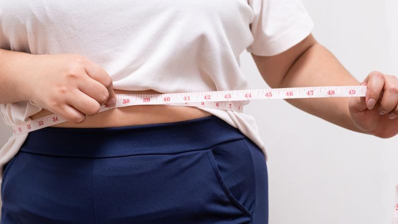 Woman measuring waist with measuring tape