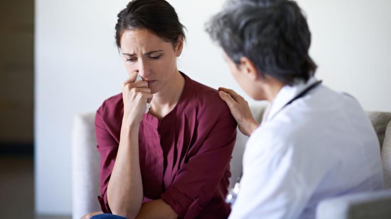 Sad patient being comforted by doctor