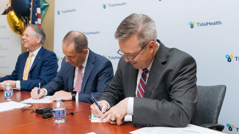 Steve Leonard, Ph.D., MBA, FACHE, president/CEO of TidalHealth, right, and Don Owrey, AGH president, sign the definitive agreement to join health systems.