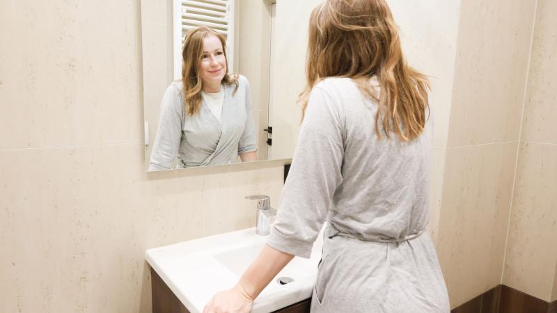 Woman looking at the mirror in a bathroom