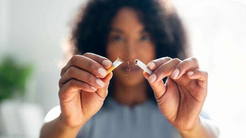 Close up on woman's hands after she breaks a cigarette in half