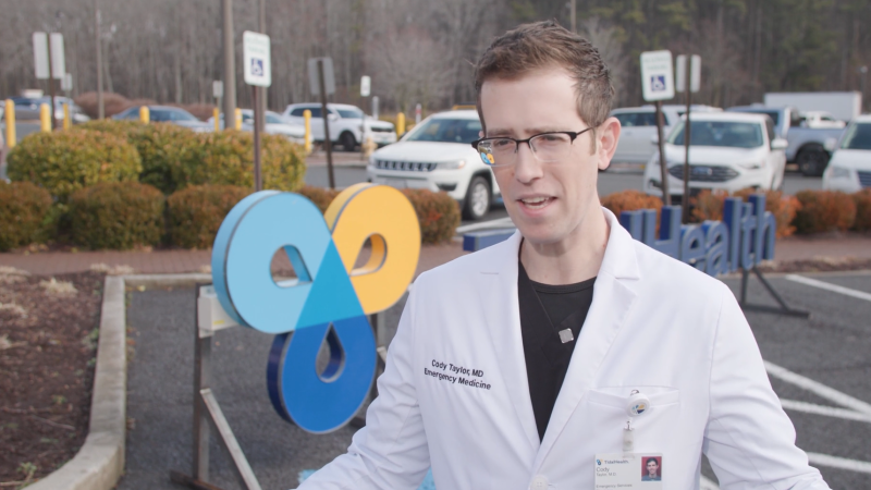 Dr. Cody Taylor speaks in front of a TidalHealth logo