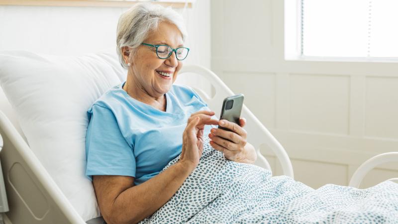 Elderly woman on phone in hospital bed
