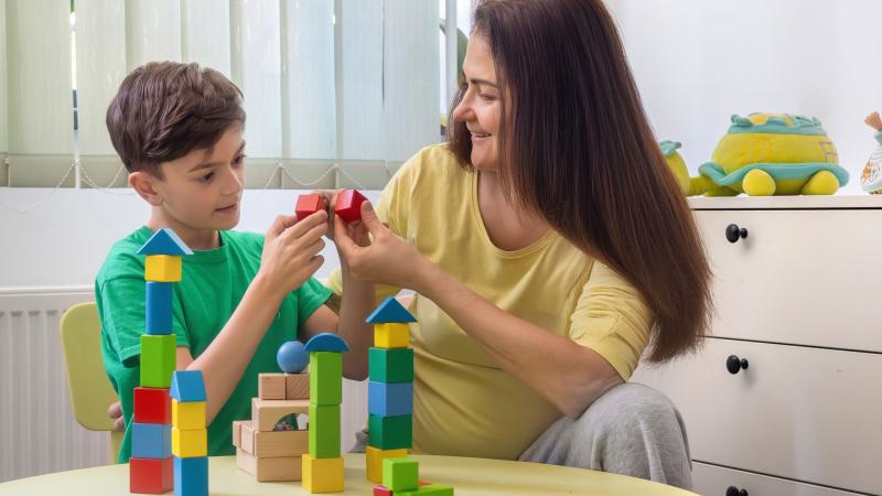 Mom plays with blocks with son who has autism