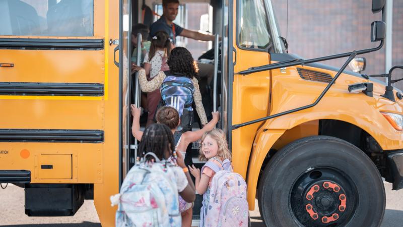Young children get onto the school bus