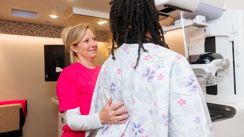Technician helps woman get a mammogram