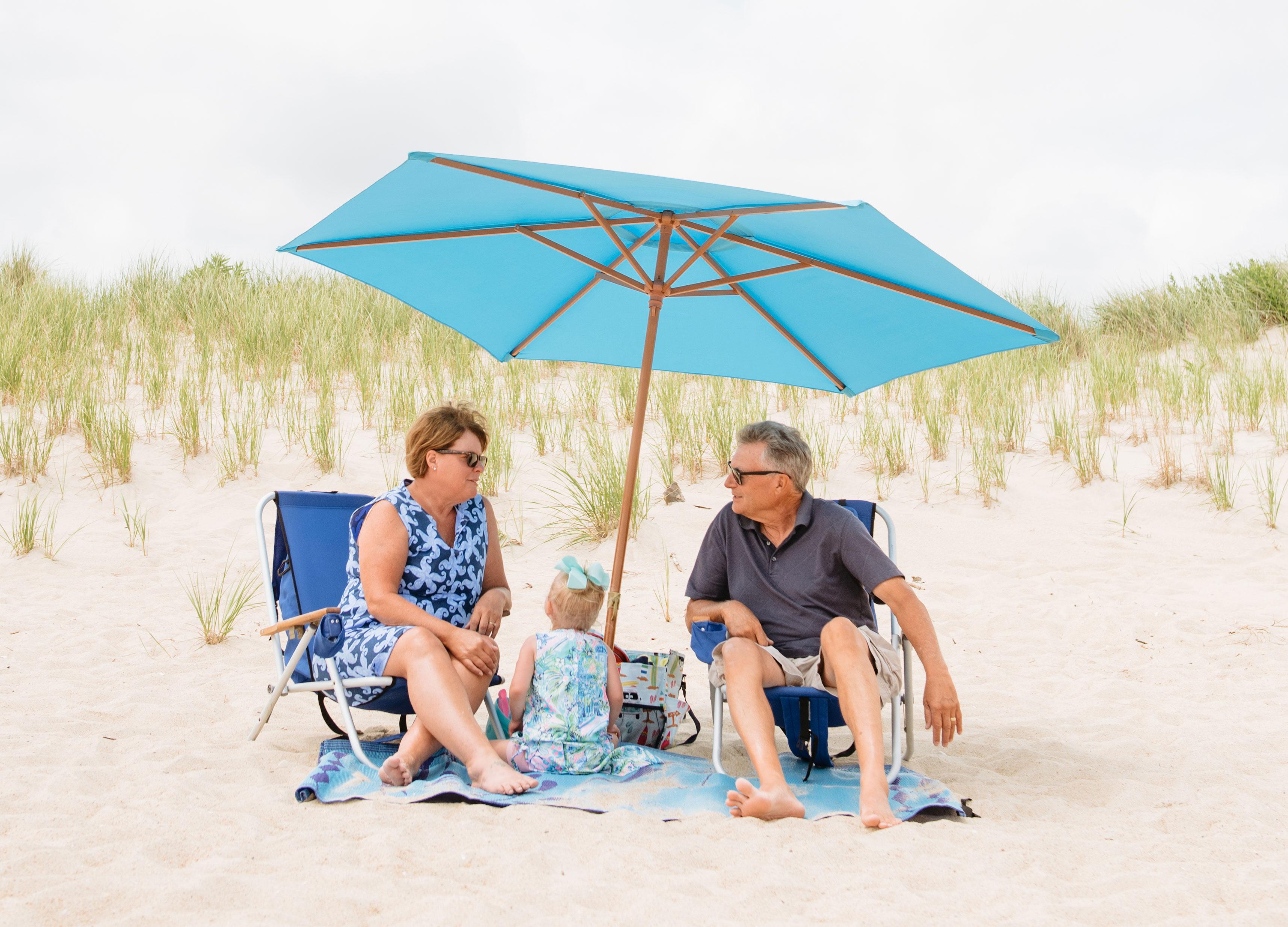 Family sitting under a beach umbrella