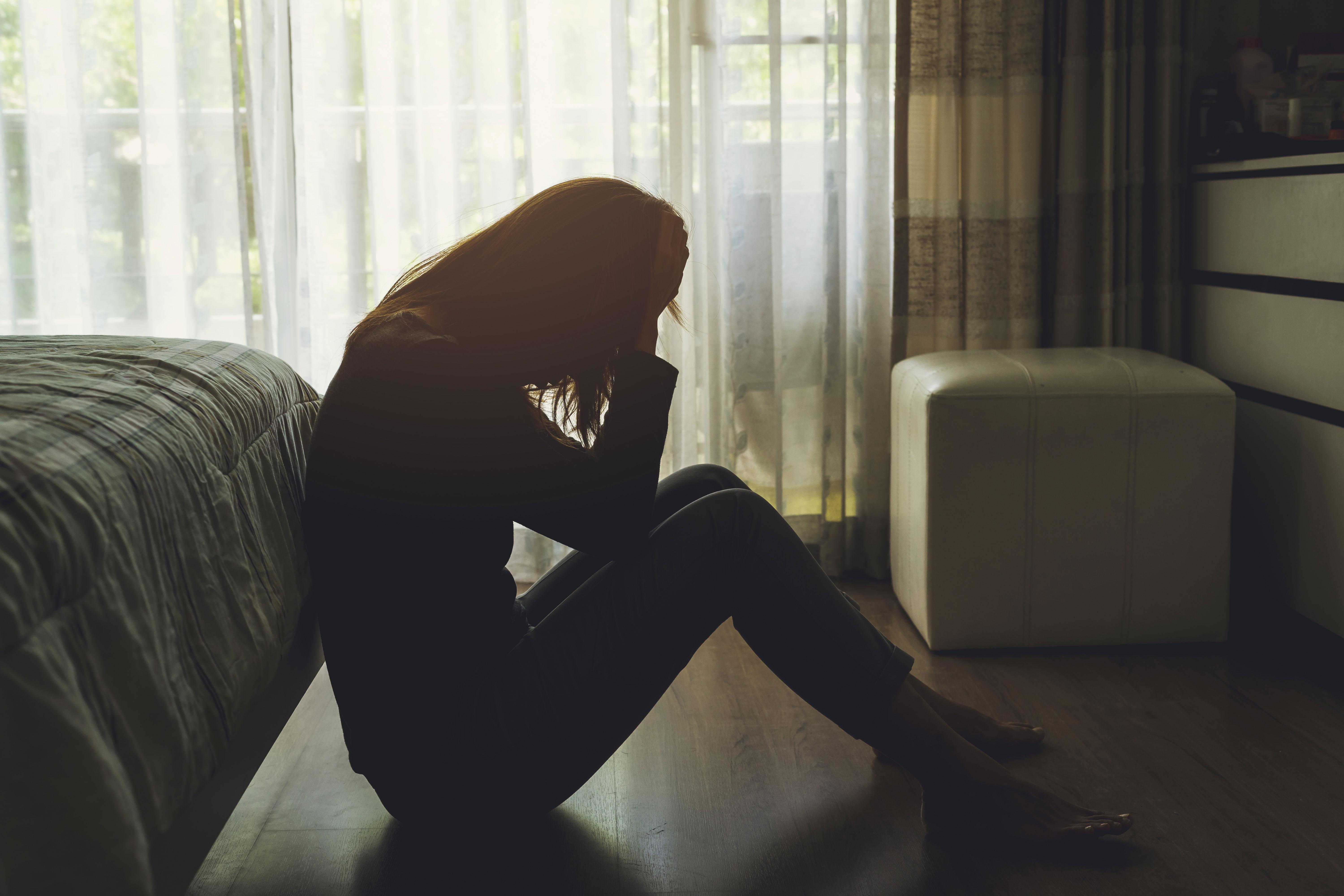 A depressed woman sitting in a dark room