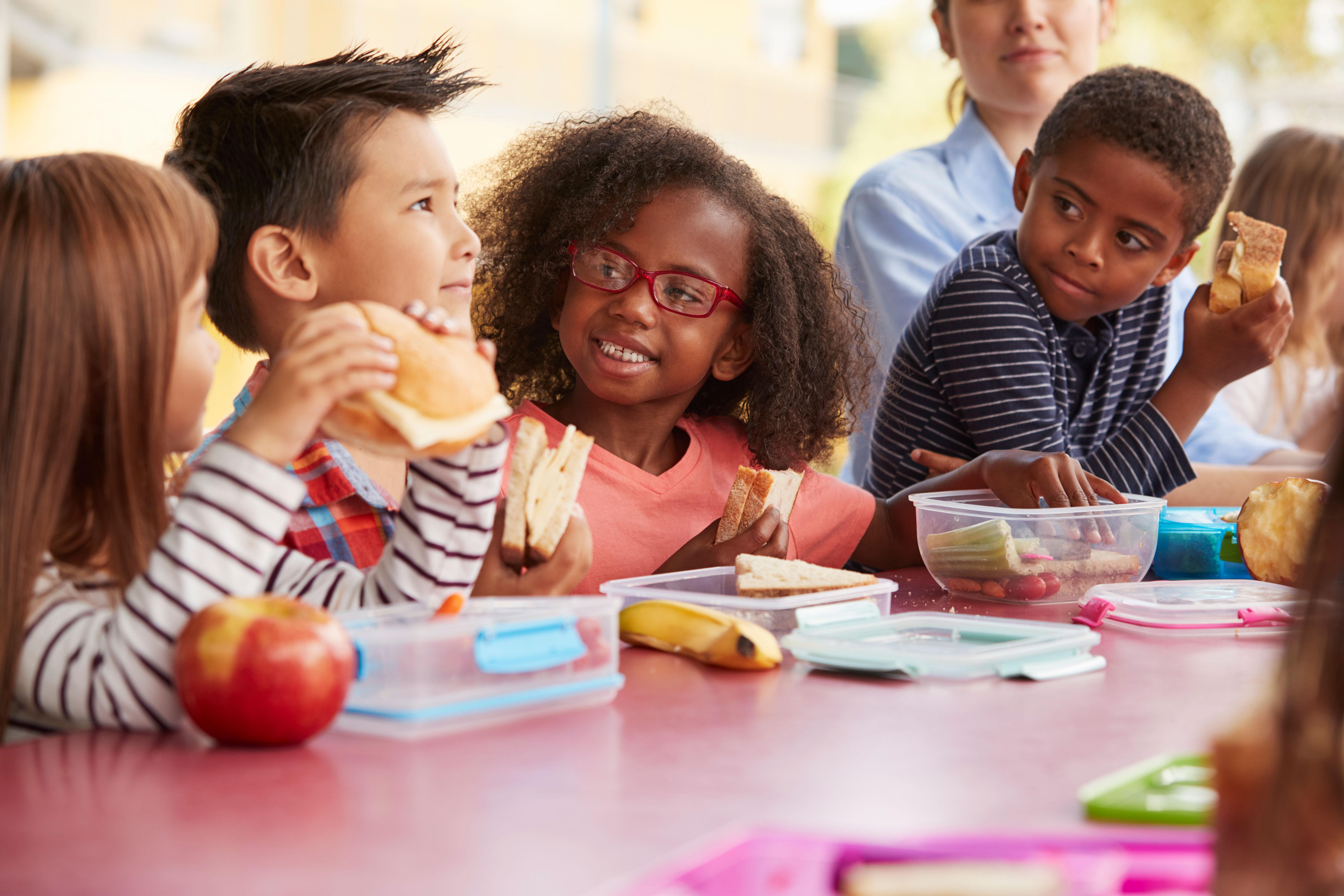 Young kids eating school lunch together