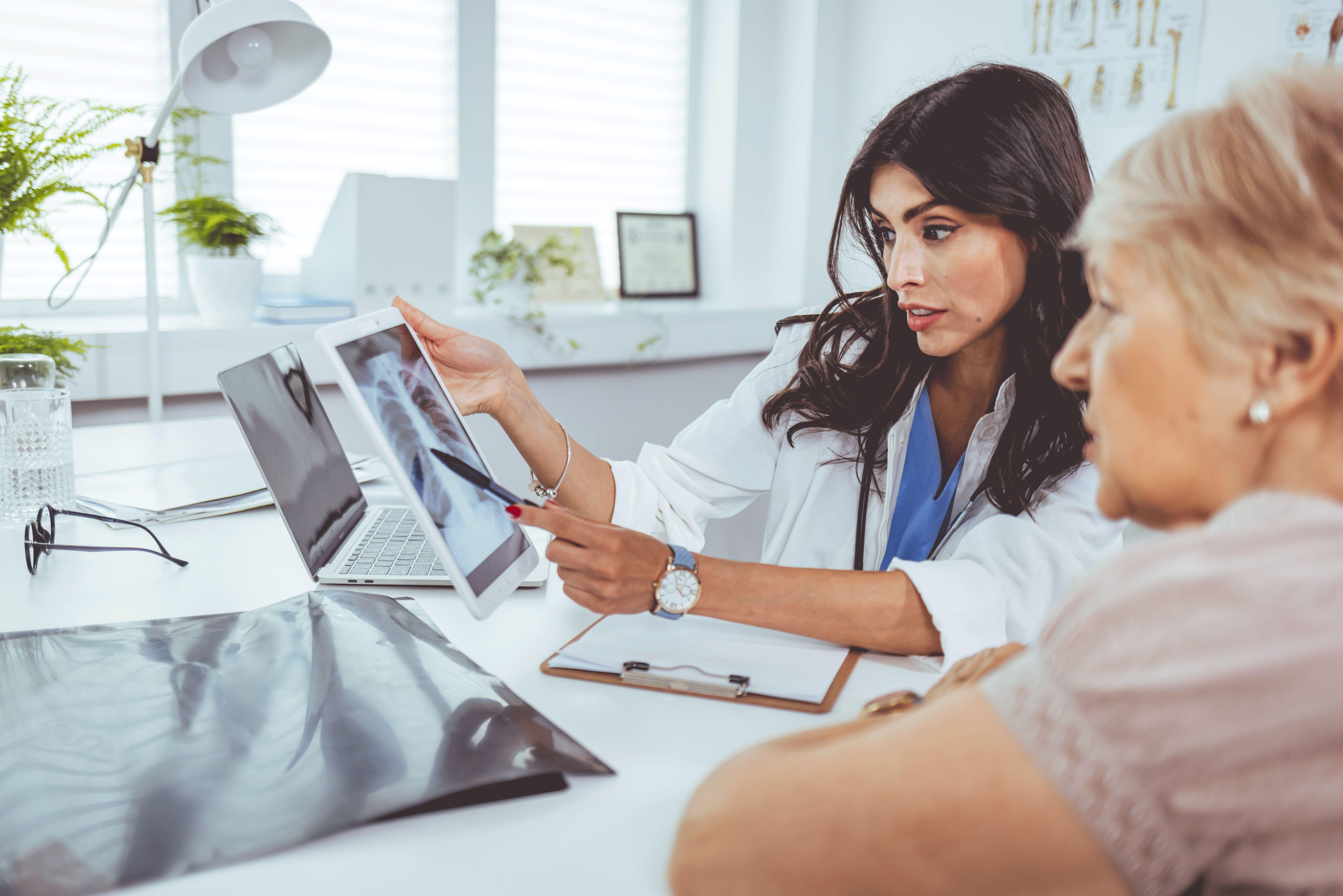 Doctor looking at lung x-ray with patient