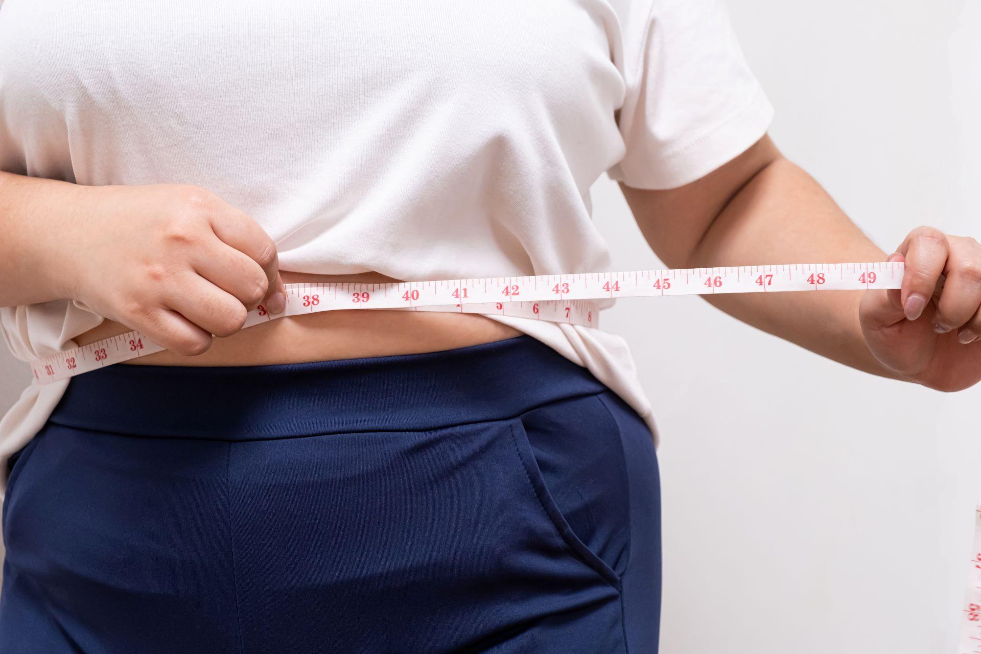 Woman measuring waist with measuring tape