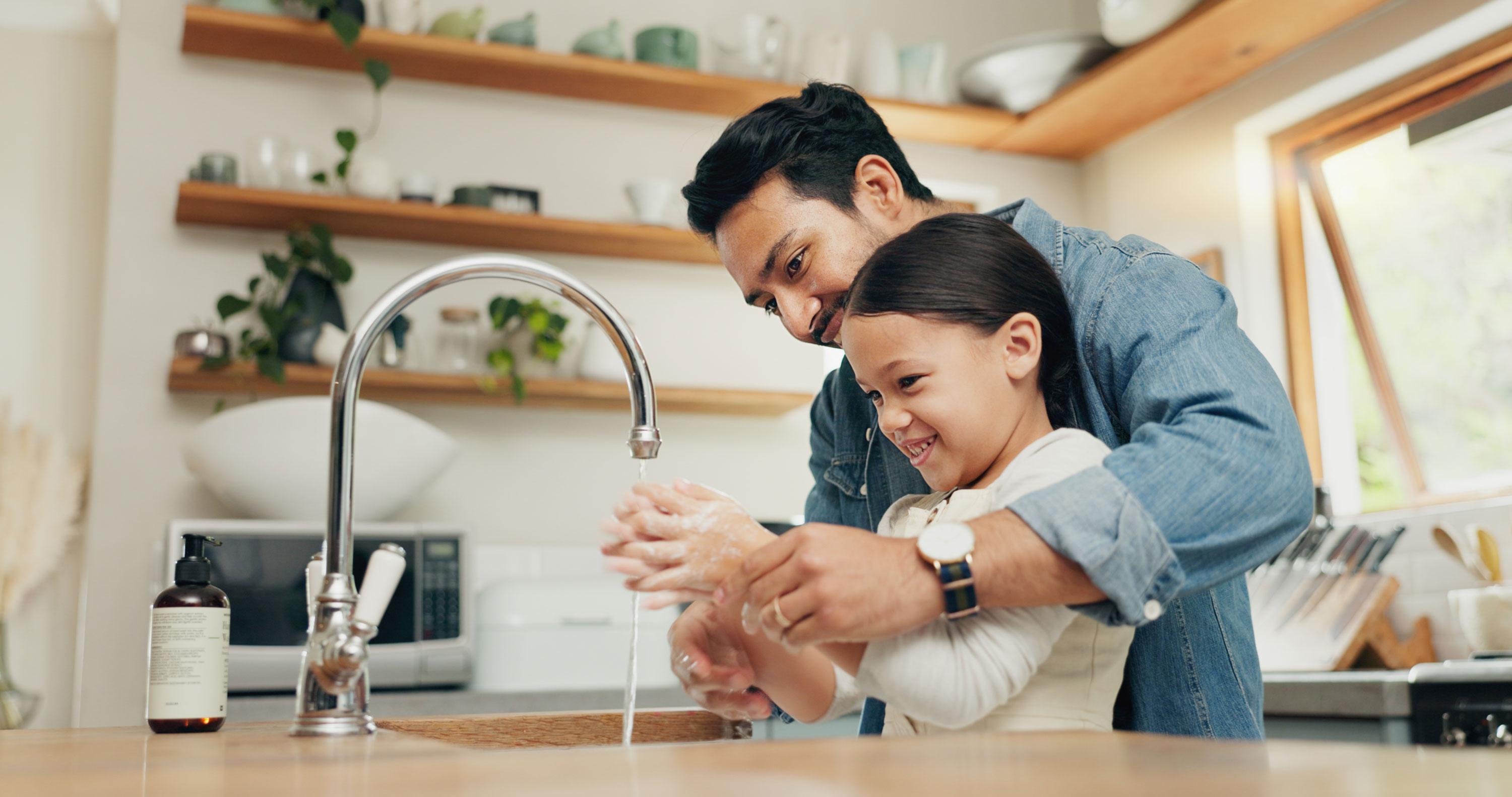 Dad and daughter washing hands in the kitchen