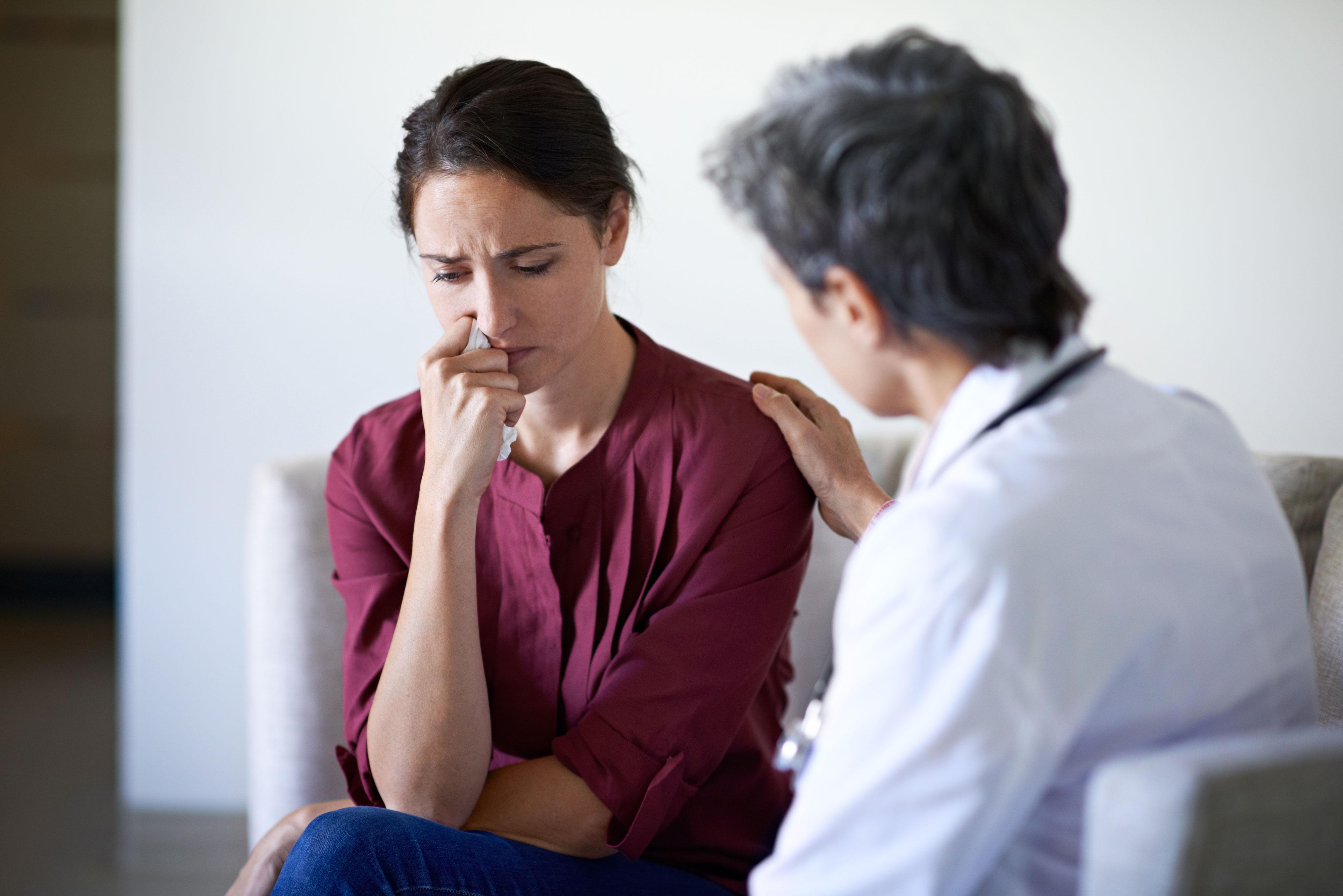 Sad patient being comforted by doctor