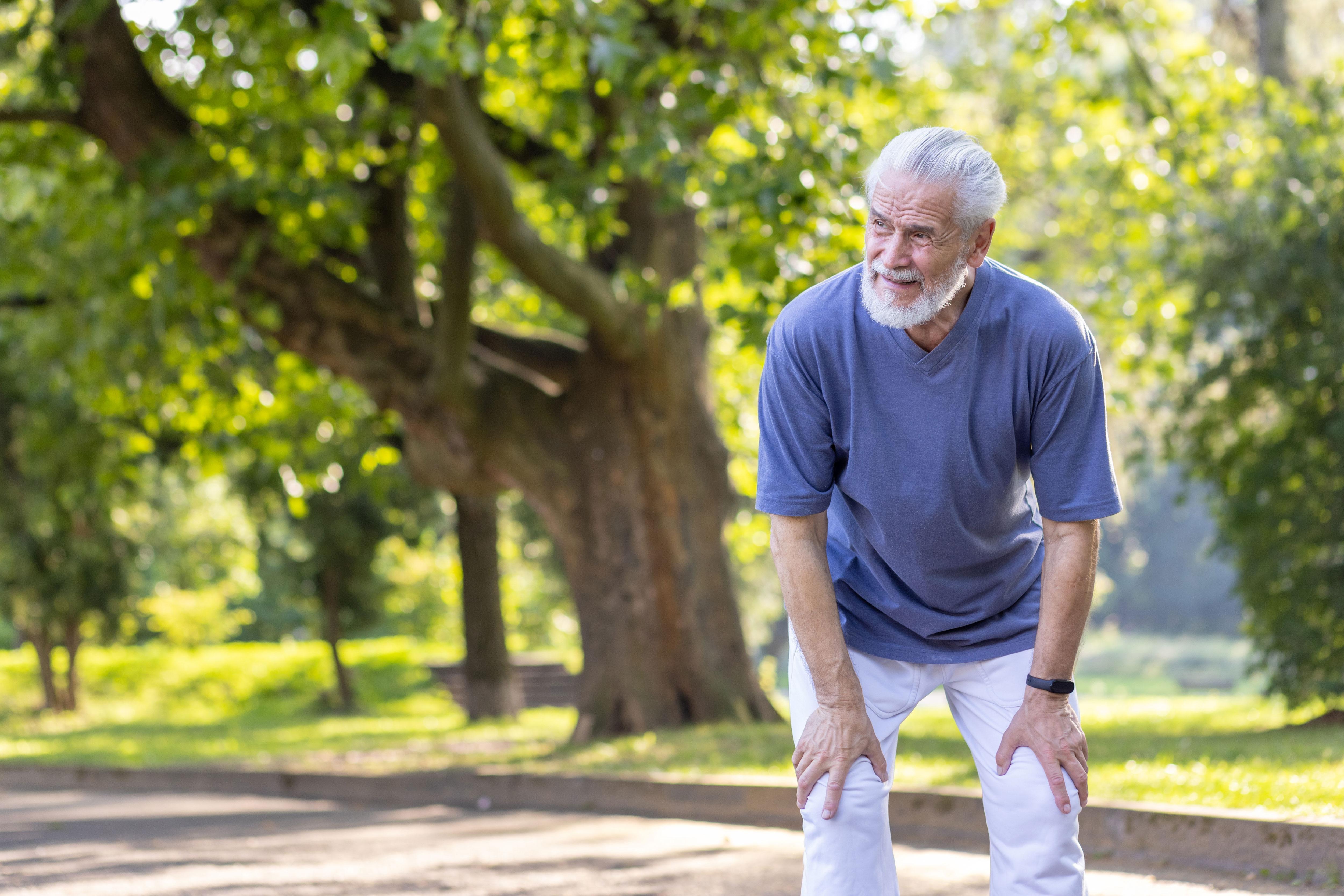 Senior man in the park with hands on legs