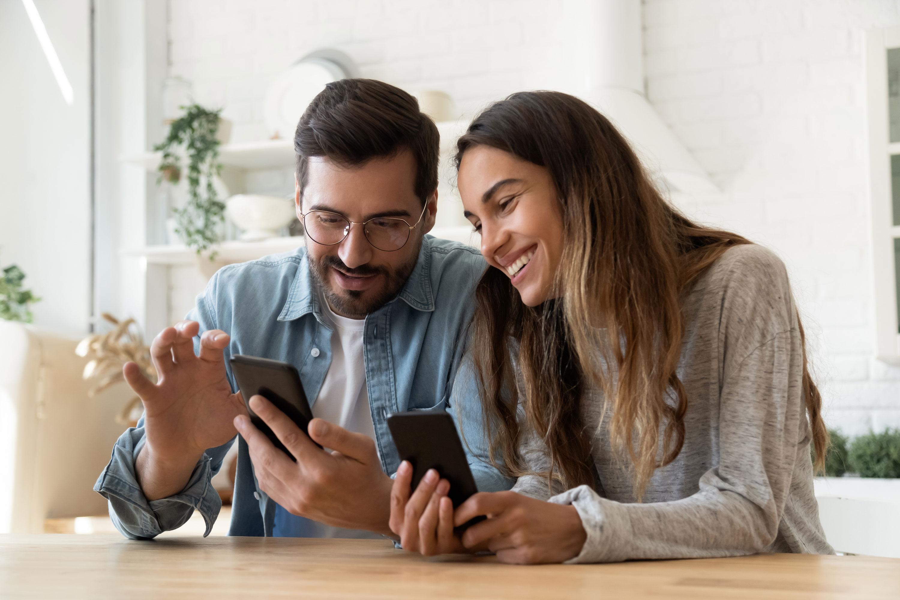 Man and woman on phones smiling
