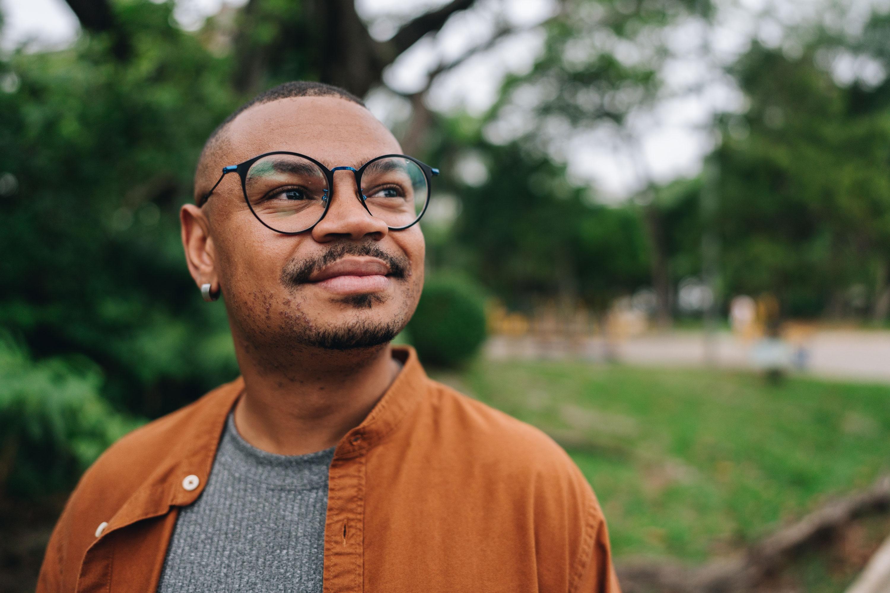 Man looking away in a park, looking hopeful