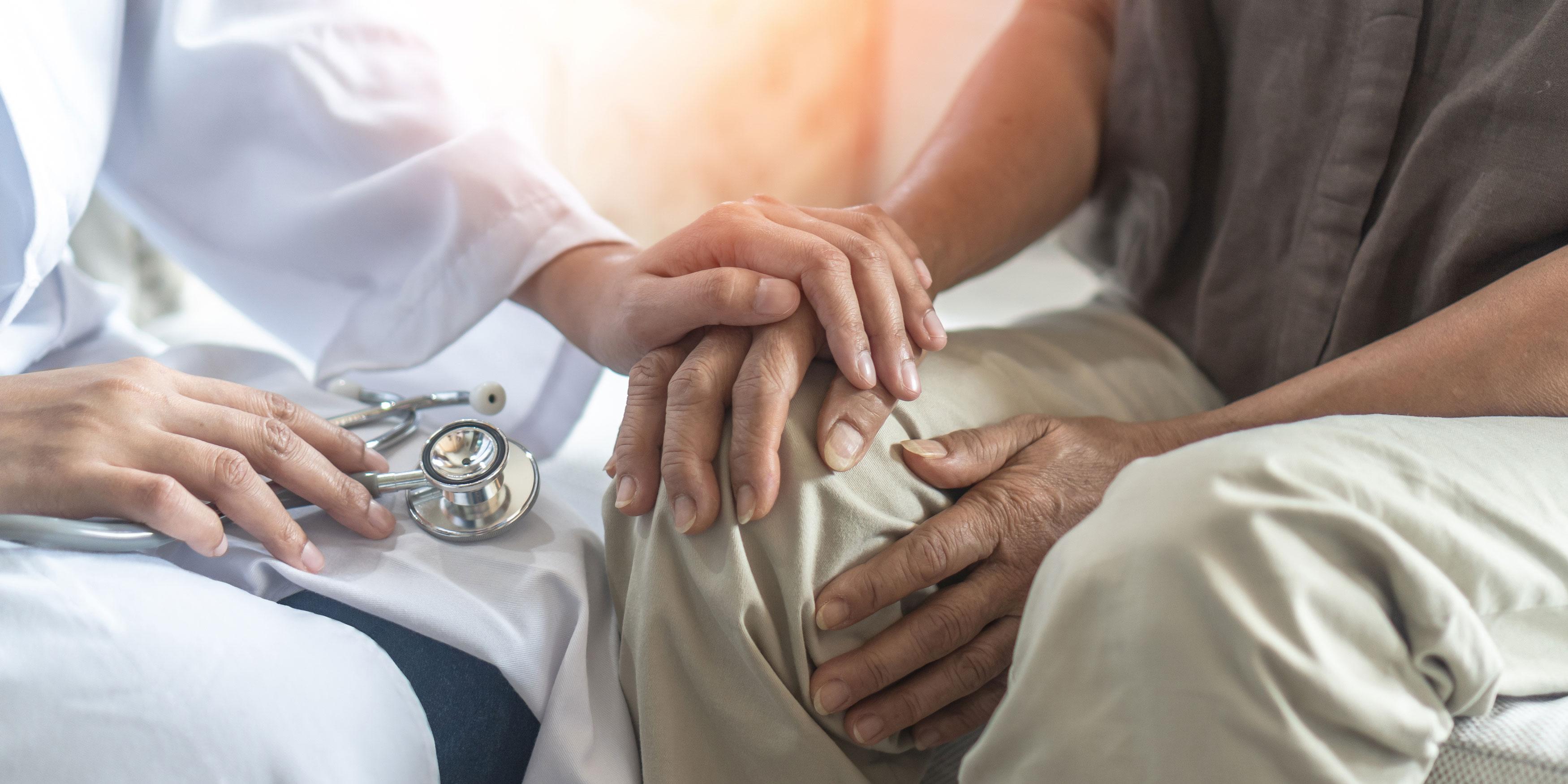 Healthcare provider with hand on top of patient's hand