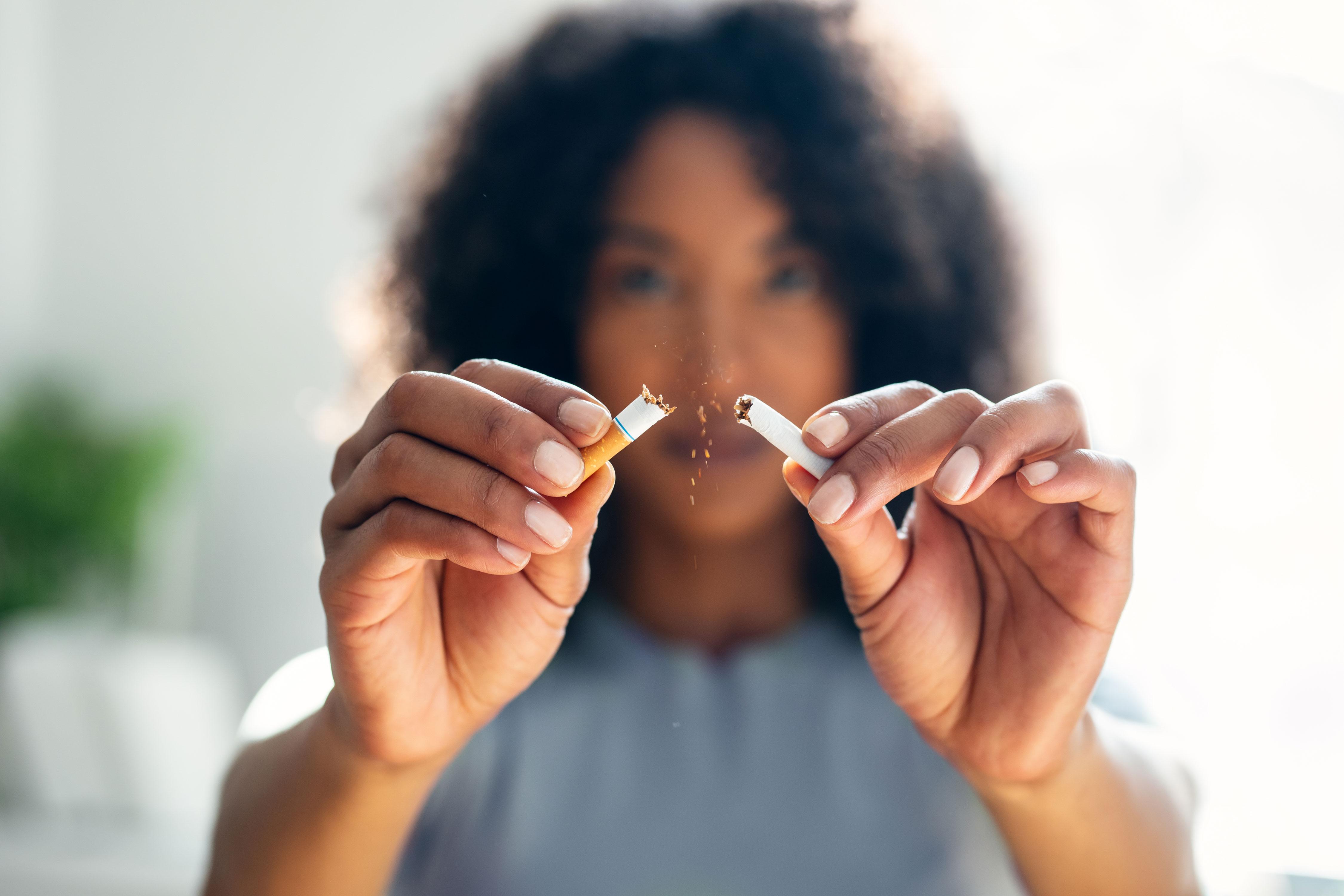 Close up on woman's hands after she breaks a cigarette in half