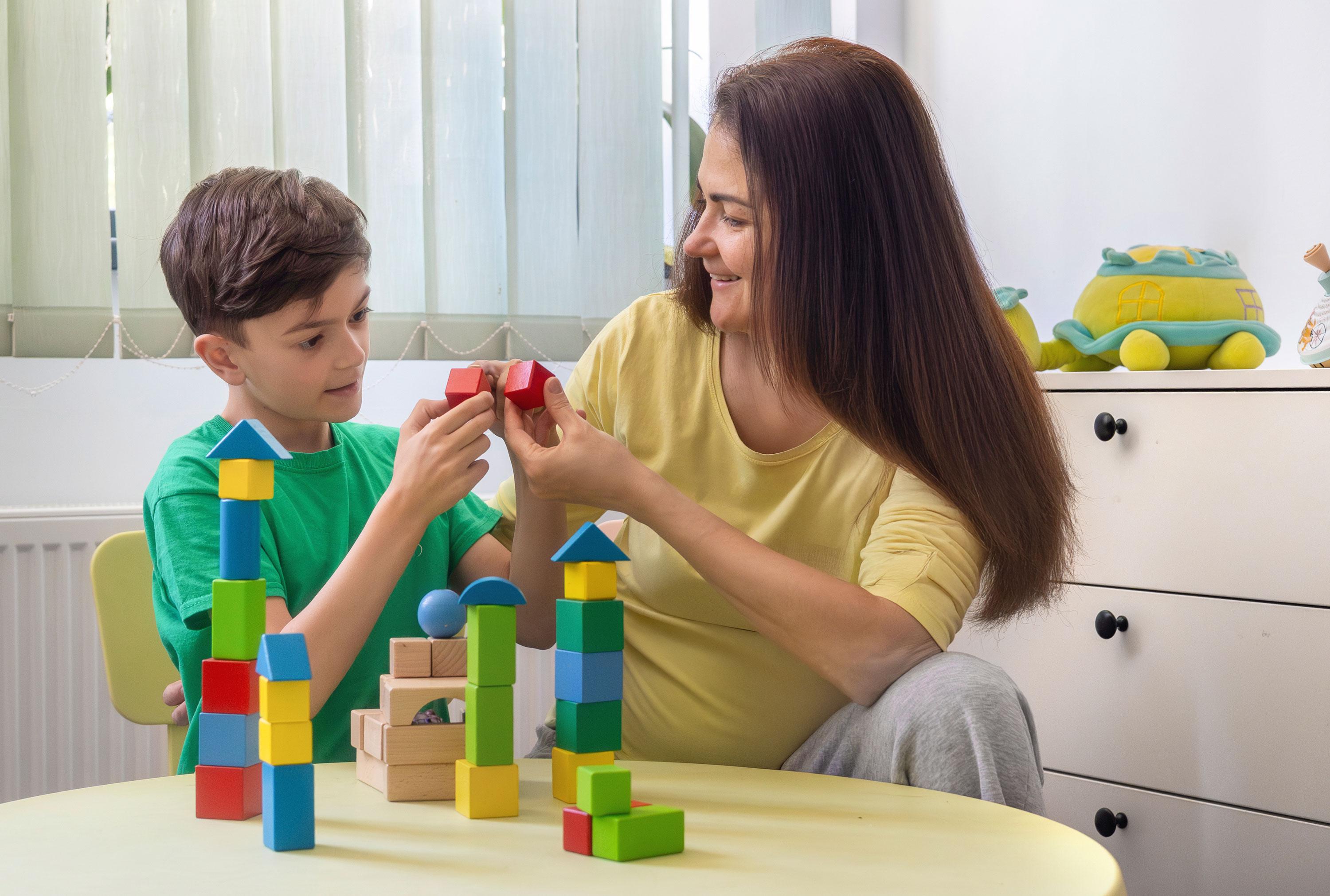 Mom plays with blocks with son who has autism