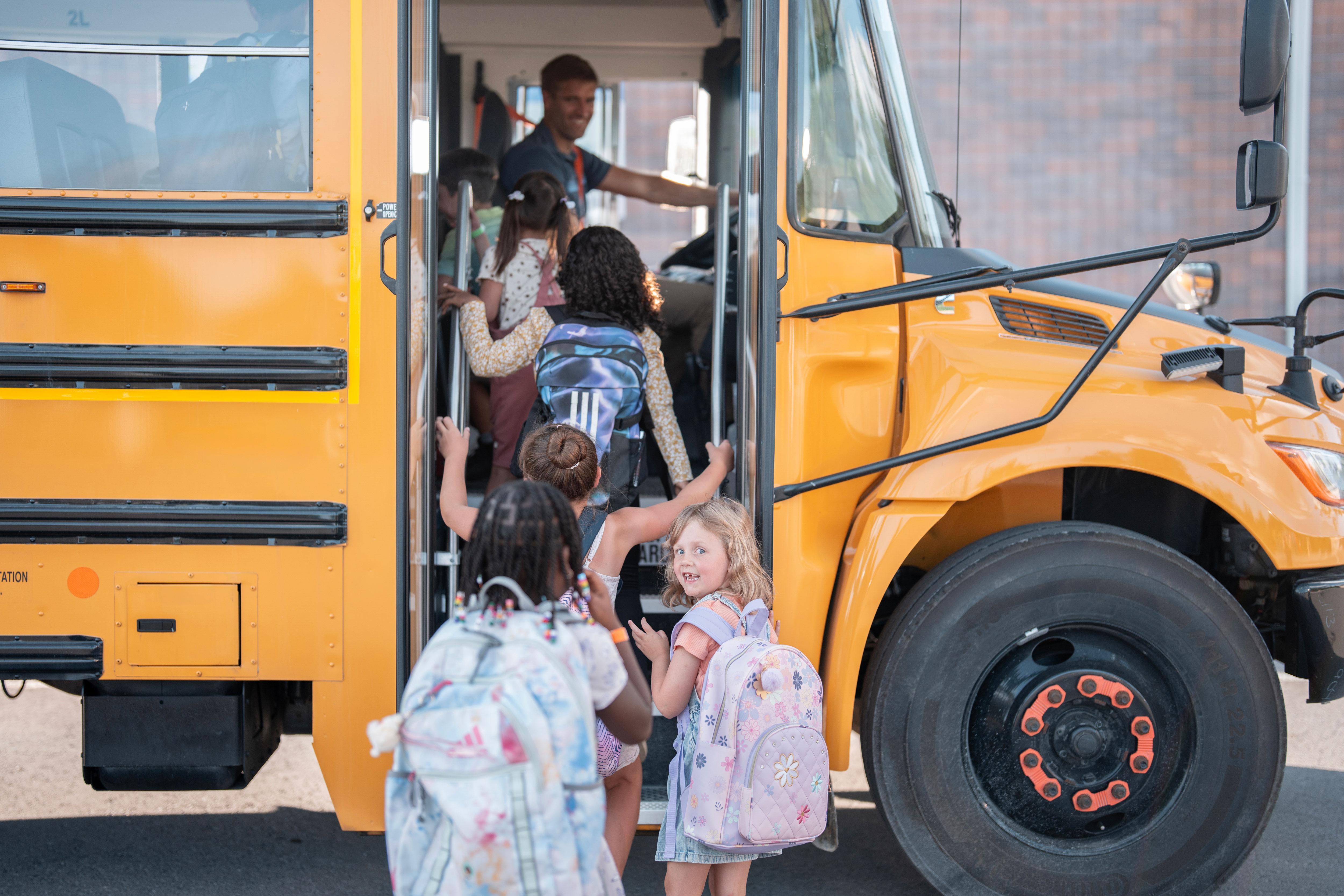 Young children get onto the school bus