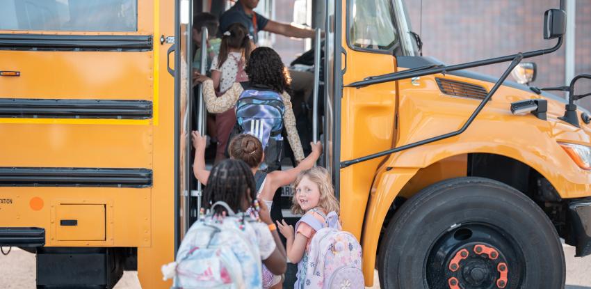 Young children get onto the school bus