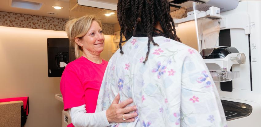 Technician helps woman get a mammogram